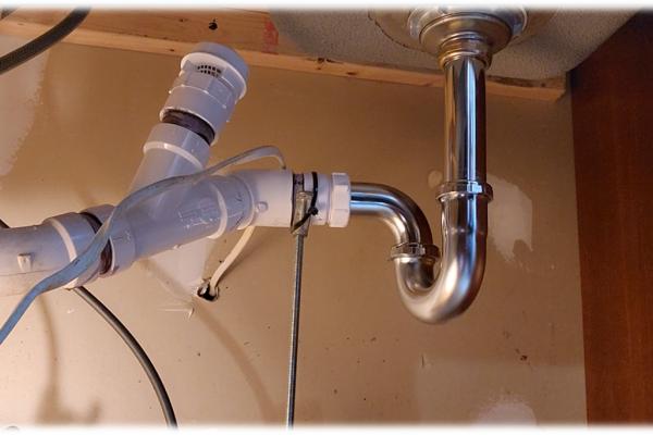 A newly installed kitchen sink drain with an added vent for enhanced functionality by Applause Plumbing in Phillipsburg, NJ. Expertly addressing previous installation issues, the replacement ensures long-term functionality and prevents recurring clogs and leaks.
