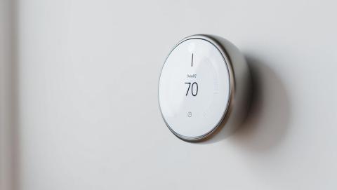 A modern smart thermostat mounted on a wall, displaying the current temperature. Learn how Met-Ed customers in Pennsylvania can get a rebate on ENERGY STAR® certified smart thermostats in our latest blog.