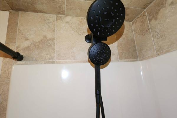 Installed dual shower head and handheld shower wand in a bathroom in Easton, PA, featuring modern plumbing fixtures for enhanced functionality.